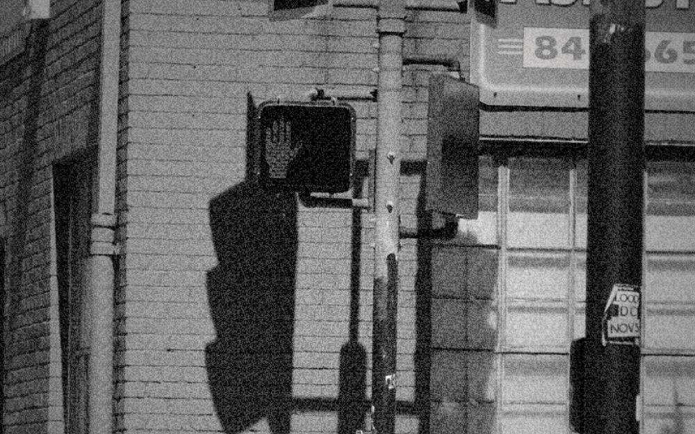 A red brick building with a traffic light and a glowing stop signal, graded as 1940: panchromatic.
