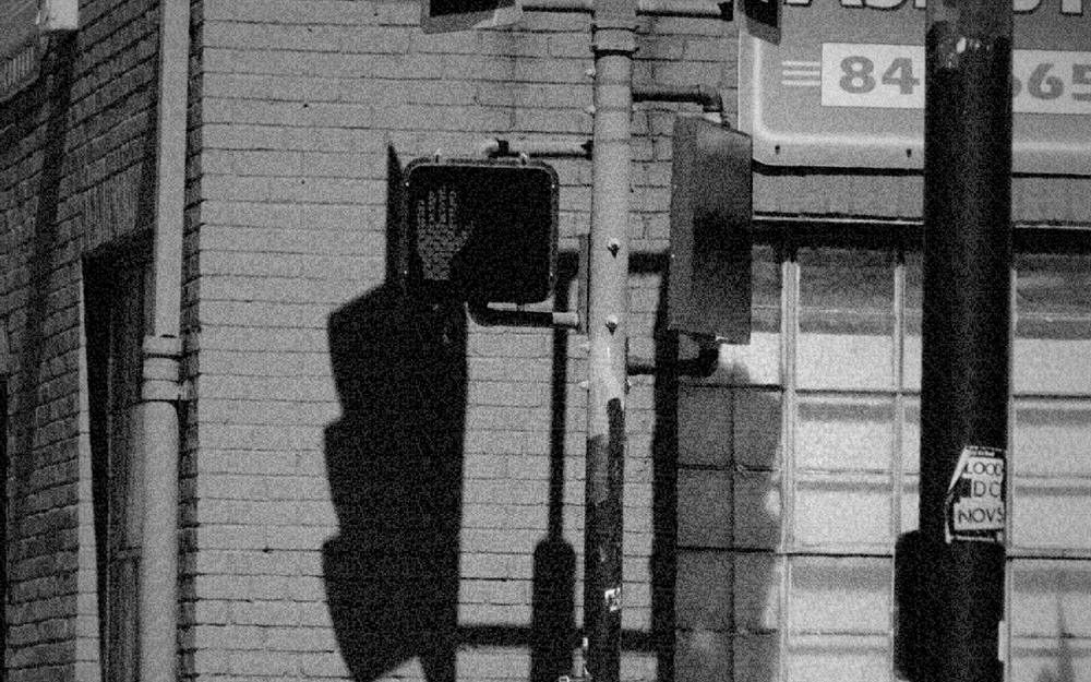 A red brick building with a traffic light and a glowing stop signal, graded as 1970: documentary.