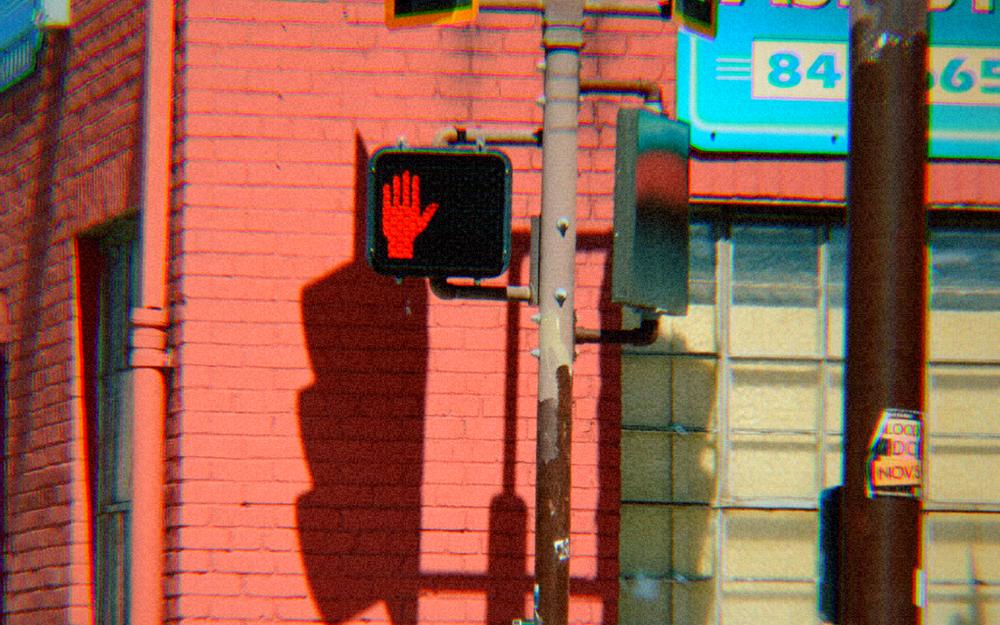 A red brick building with a traffic light and a glowing stop signal, graded as 1980: vhs.