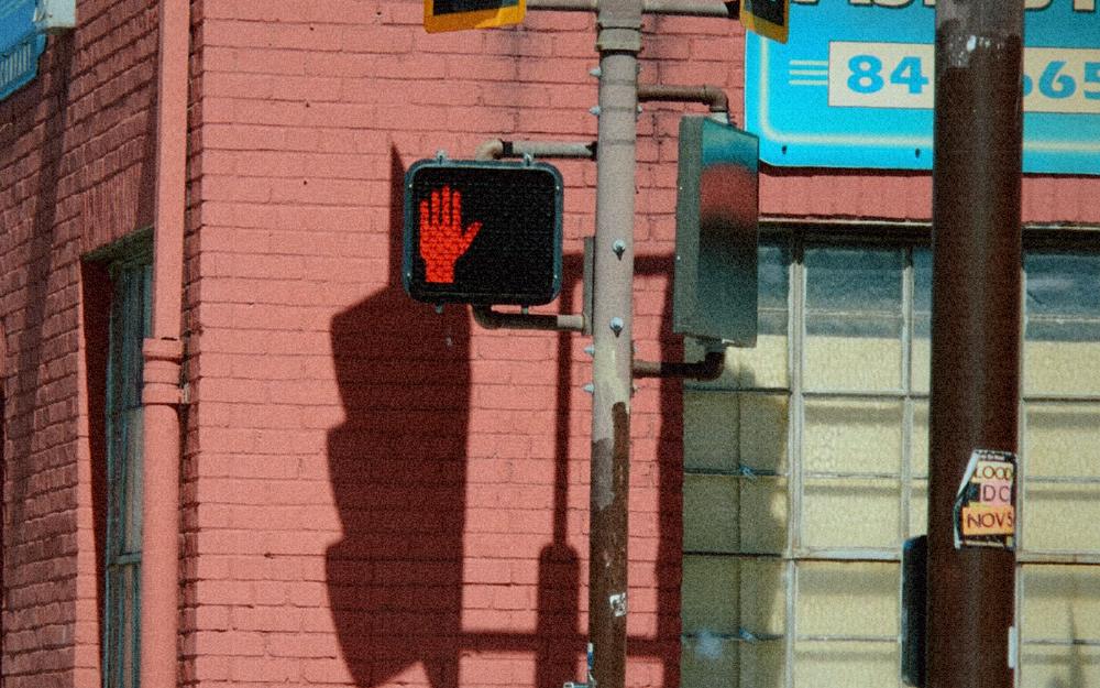 A red brick building with a traffic light and a glowing stop signal, graded as 2000: ccd digicam.