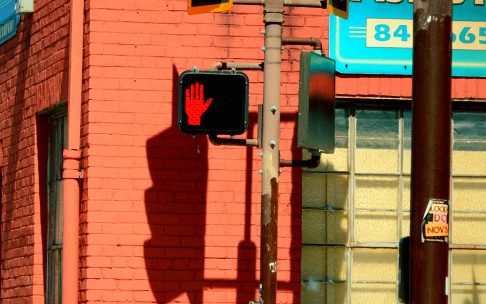 A red brick building with a traffic light and a glowing stop signal, graded as 2010: early smartphone.